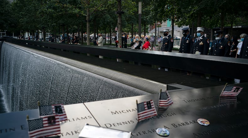 FILE -- People stand at the 9/11 Memorial in New York, on Friday, Sept. 11, 2020, the 19th anniversary of the Sept. 11 terror attacks. (Todd Heisler/The New York Times)