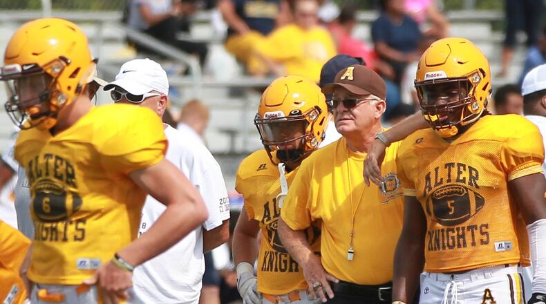 Alter High School football head coach Ed Domsitz (middle) huddles with junior running back Branden McDonald during a scrimmage at Beavercreek on Saturday, Aug. 17, 2019. MARC PENDLETON / STAFF