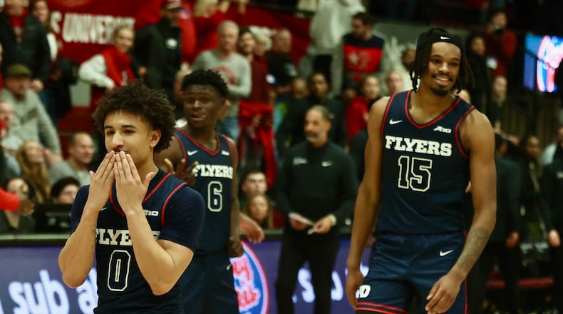 Dayton's Javon Bennett, left, and DaRon Holmes II celebrate a victory against Saint Joseph’s on Tuesday, Feb. 6, 2024, at Hagan Arena in Philadelphia. David Jablonski/Staff
