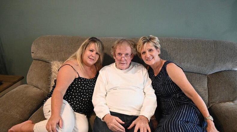 On the first day they met, half-sisters Tammy Pitzen and Jane Koester (right) pose with their dad, DanTucker. CONTRIBUTED