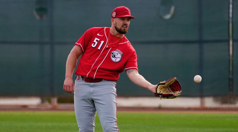 Cincinnati Reds starting pitcher Graham Ashcraft (51) catches a ball during an MLB spring training baseball practice, Friday, Feb. 17, 2023, in Goodyear, Ariz. (AP Photo/Matt York)