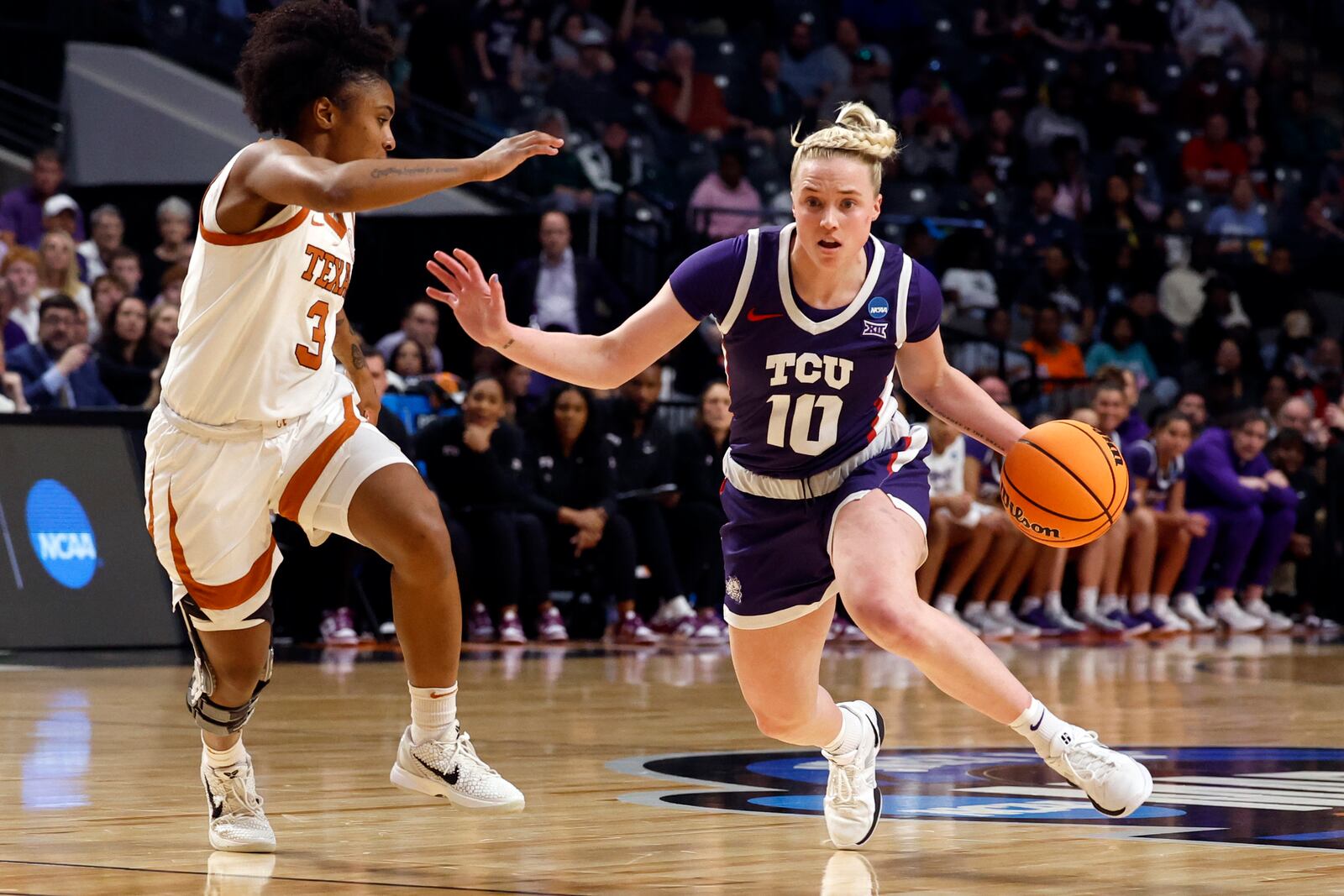 TCU guard Hailey Van Lith (10) dribbles around Texas guard Rori Harmon (3) during the first half in the Elite Eight of the NCAA college basketball tournament, Monday, March 31, 2025, in Birmingham, Ala. (AP Photo/Butch Dill)