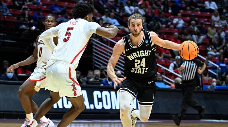 Wright State guard Tim Finke (24) drives past Arizona guard Justin Kier (5) during the first half of a first-round NCAA college basketball tournament game, Friday, March 18, 2022, in San Diego. (AP Photo/Denis Poroy)