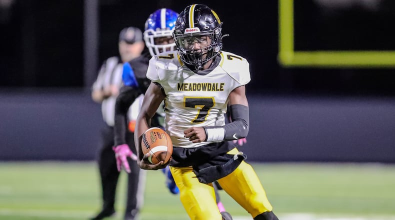 Meadowdale High School junior Jordan Brown runs past a Dunbar defender during their game on Thursday night at Dayton Welcome Stadium. The Lions won 44-14. CONTRIBUTED PHOTO BY MICHAEL COOPER