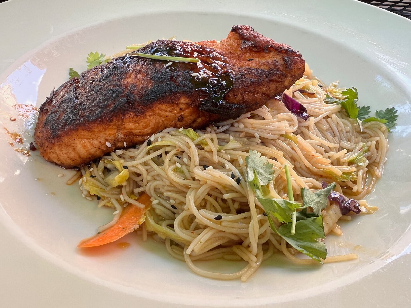 Lily's in the Oregon District celebrates 11 years. The vermicelli noodle stir fry bowl packed with cabbage, onions, peppers, carrots and garlic and topped with pan seared salmon ($22).