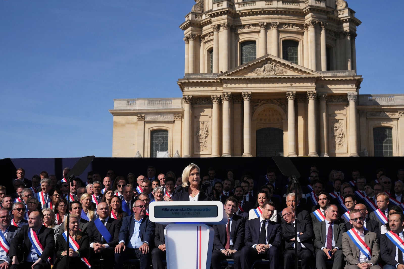 French far-right leader Marine Le Pen delivers her speech during the French far-right party national rally near the parliament in Paris, Sunday, April 6, 2025. (AP Photo/Michel Euler)