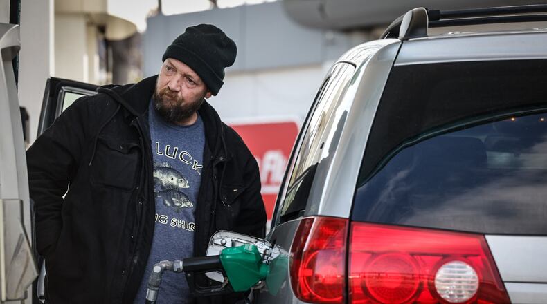 Mark Frawleg, from Dayton, pumps gas at the BP on Edwin C. Moses Boulevard Tuesday, Dec. 3. JIM NOELKER/STAFF