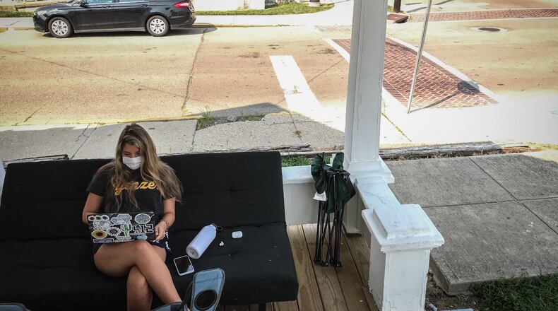 Bree Nurray, a University of Dayton senior from Pittsburgh, takes an online class on the front porch of her rental house on the campus Wednesday August 26, 2020.