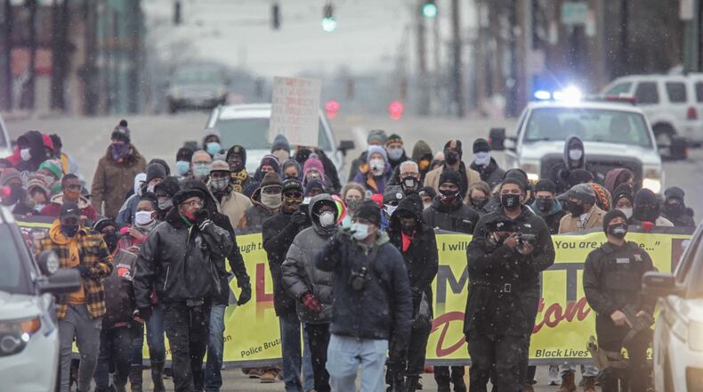 Snow flurries were falling Monday during a march on Martin Luther King Jr. Day. Around 100 people braved the cold for the march that started at Drew Health Center on West Third Street and ended at the Third Street bridge in Dayton.