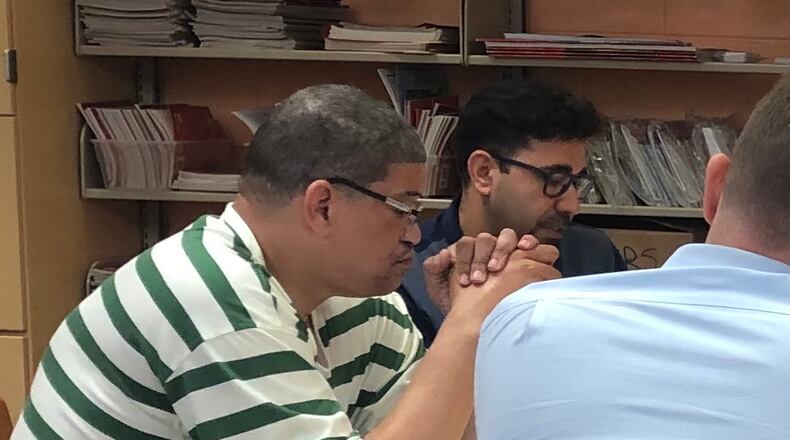 Dayton school board members William Harris (left) and Mohamed Al-Hamdani (center) spend a Saturday morning in June 2019 going over financial options for the Dayton school district. The two will not run for re-election in November 2021. JEREMY P. KELLEY / STAFF