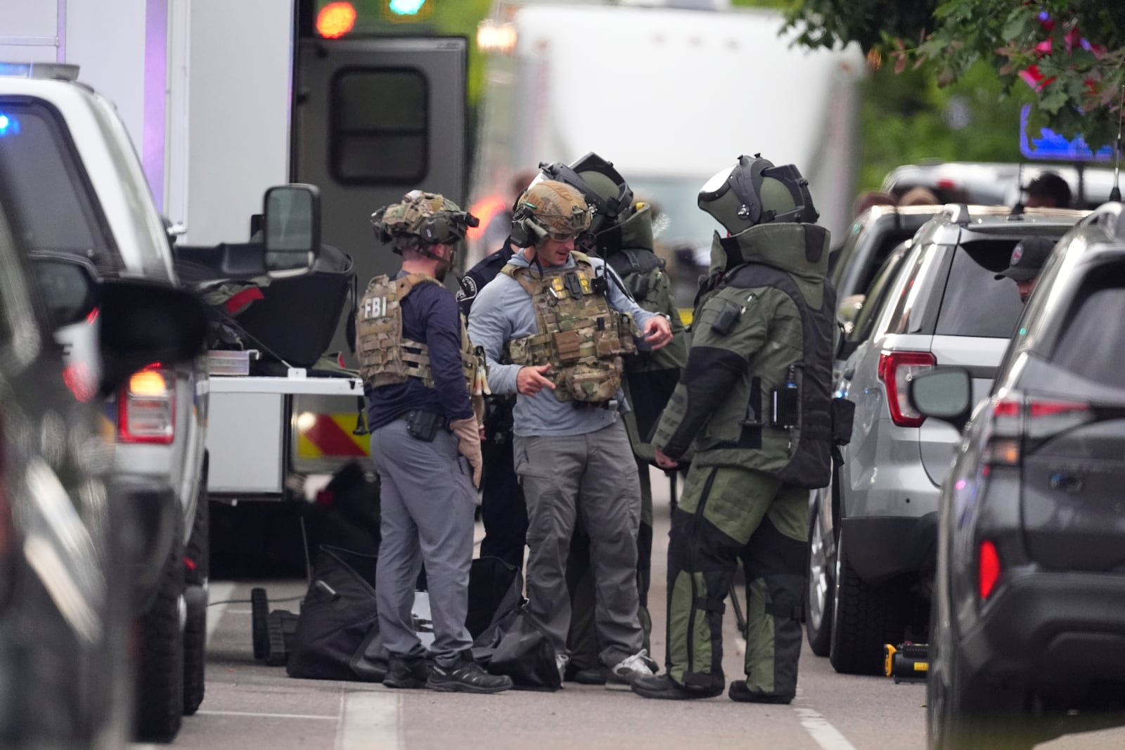 Law enforcement officials dress to investigate after an attack on the Peark Street Mall Sunday, June 1, 2025, in Boulder, Colo. (AP Photo/David Zalubowski)