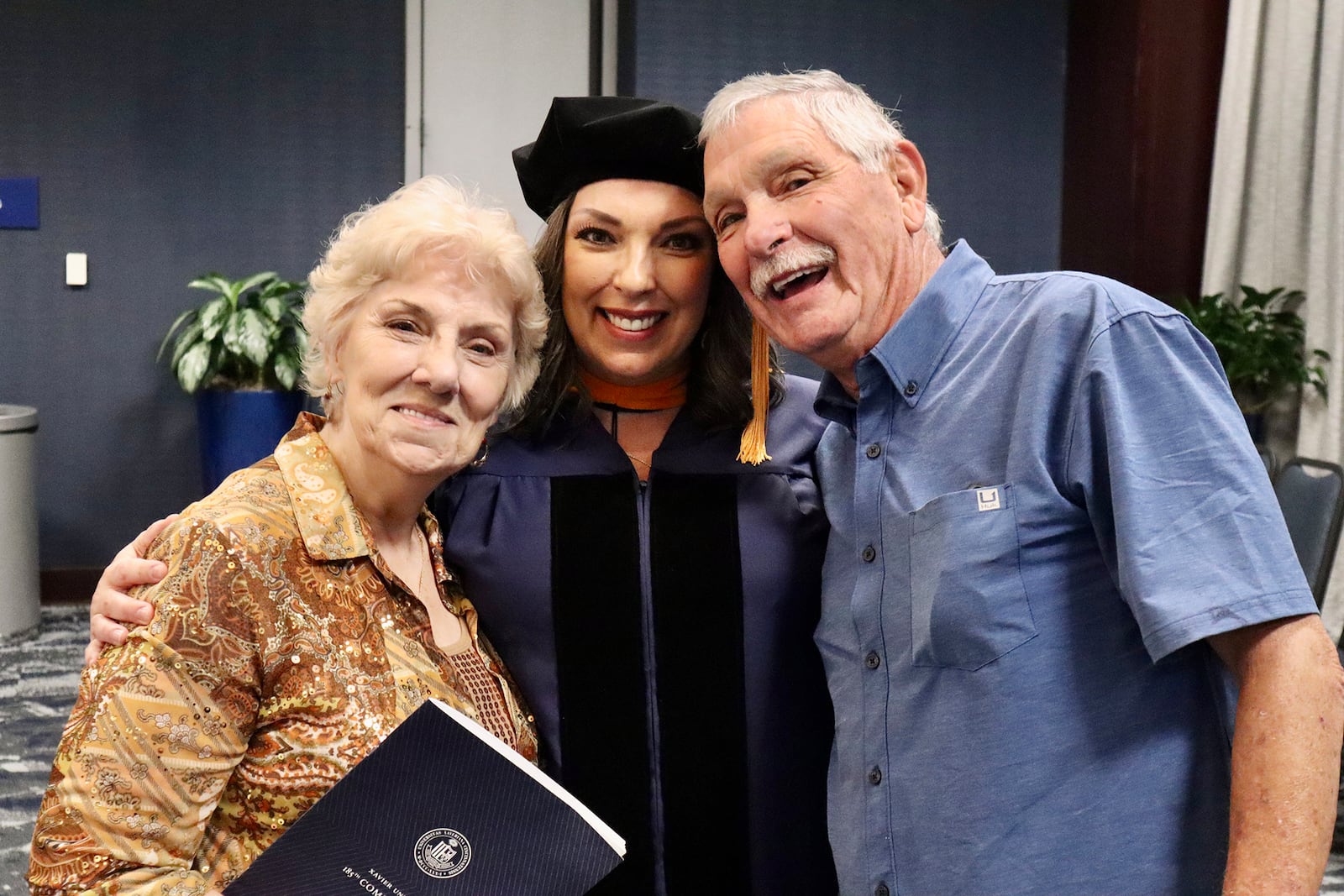 Tiffany Thompson (center) with her parents - mom Charlotte Phillips (left) and dad Kermit Phillips (right) - at her doctorate graduation at Xavier University in 2023. CONTRIBUTED