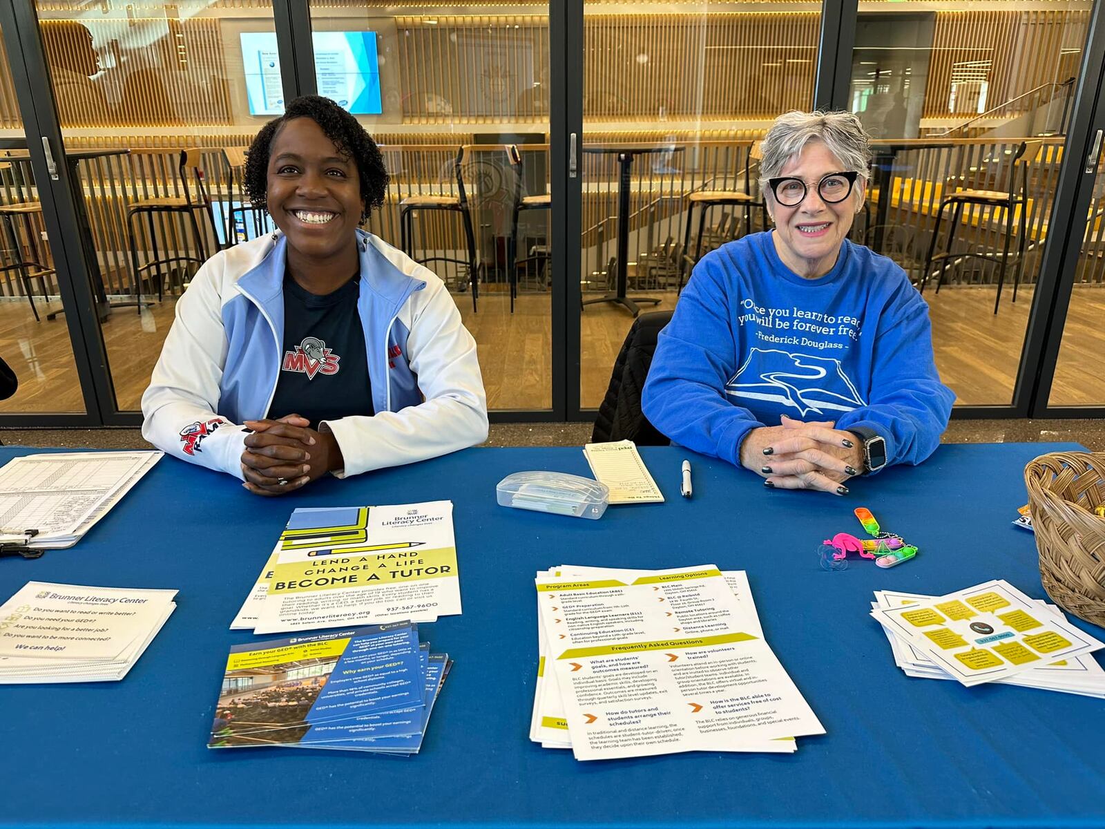 Watson (R) with BLC executive director Myla Cardona-Jones at a BLC resource table at the Dayton Metro Library. Watson spends most of her time in the community, talking about adult literacy and BLC as well as recruiting tutors.