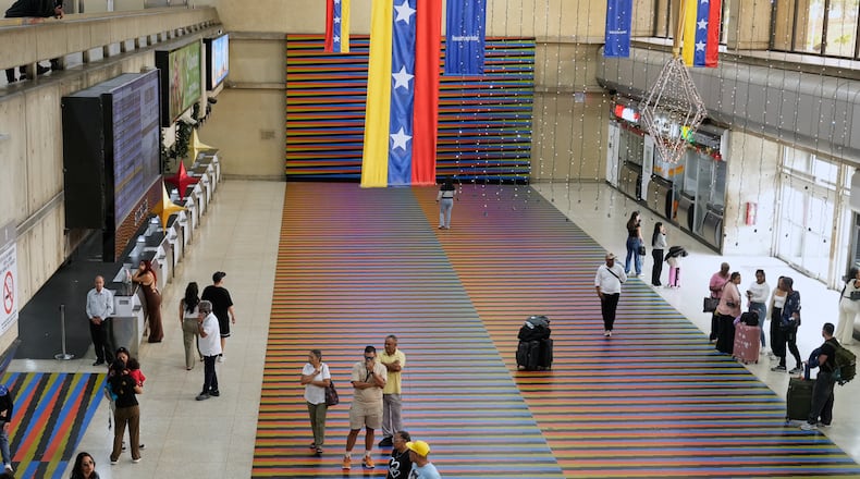 Travelers wait in the main hall of the Simon Bolivar Maiquetia International Airport in Maiquetia, Venezuela, Sunday, Nov. 13, 2025, after several international airlines canceled flights following a warning from the U.S. Federal Aviation Administration about a hazardous situation in Venezuelan airspace. (AP Photo/Ariana Cubillos)