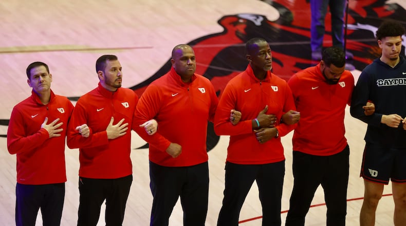 Dayton coaches stand for the national anthem before a game against Saint Joseph’s on Tuesday, Feb. 6, 2024, at Hagan Arena in Philadelphia. David Jablonski/Staff