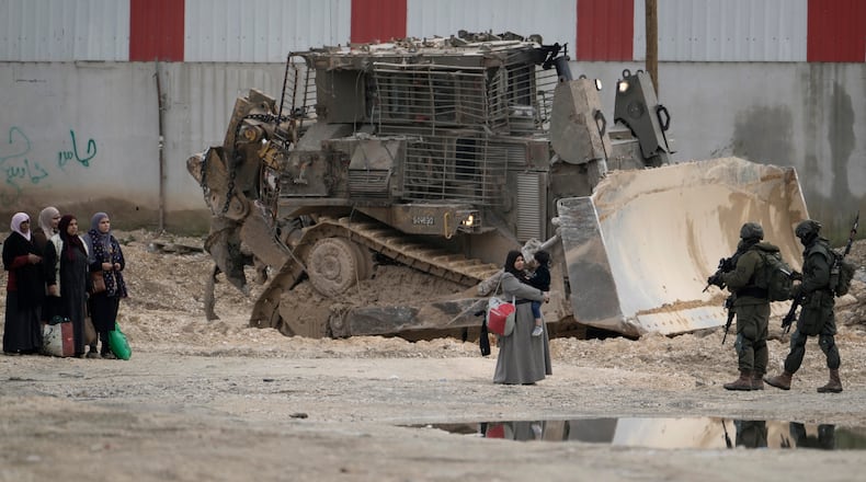 FILE -Israeli soldiers check the identification cards of Palestinians while they evacuate their homes in the West Bank refugee camp of Nur Shams, near Tulkarem, while the Israeli military operation continues in the area on, Feb. 11, 2025. (AP Photo/Majdi Mohammed, File)