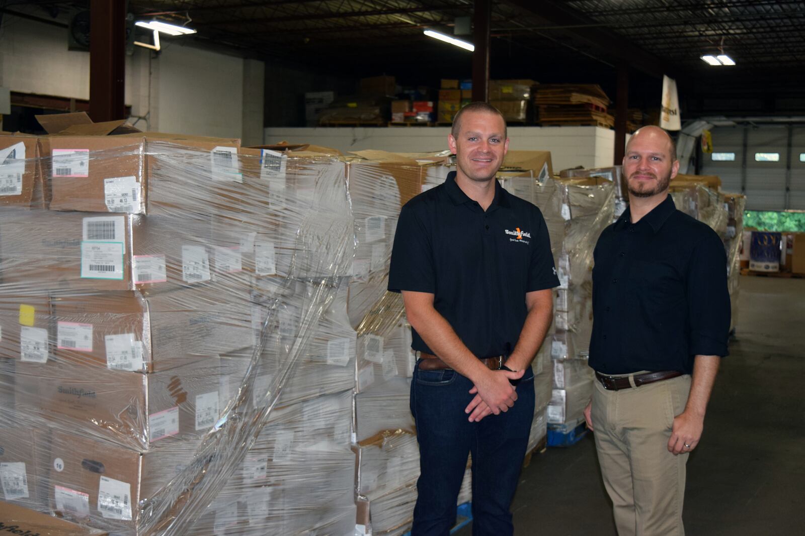 Zachary Freeman of Smithfield Foods presents 35,000 pounds of protein to Terry Perdue, Chief Fiscal Officer for Shared Harvest Foodbank.