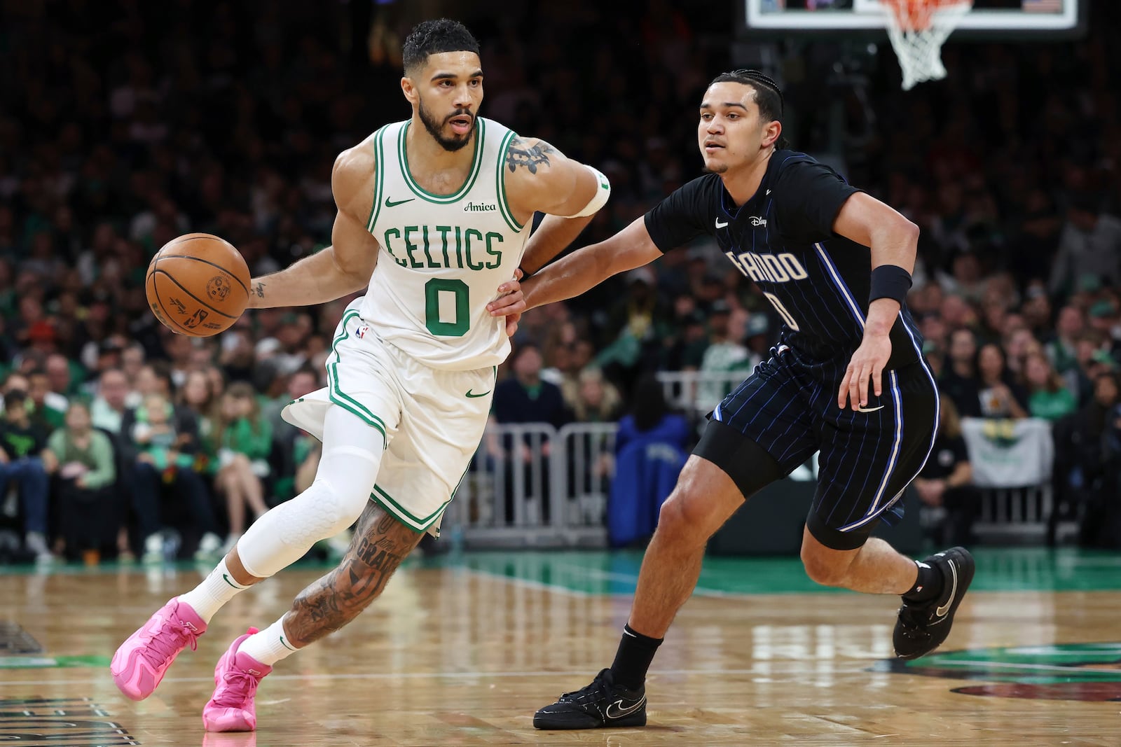 Boston Celtics' Jayson Tatum, left, drives past Orlando Magic's Anthony Black during the first half in game 1 of a first-round NBA playoff basketball series Sunday, April 20, 2025, in Boston. (AP Photo/Michael Dwyer)