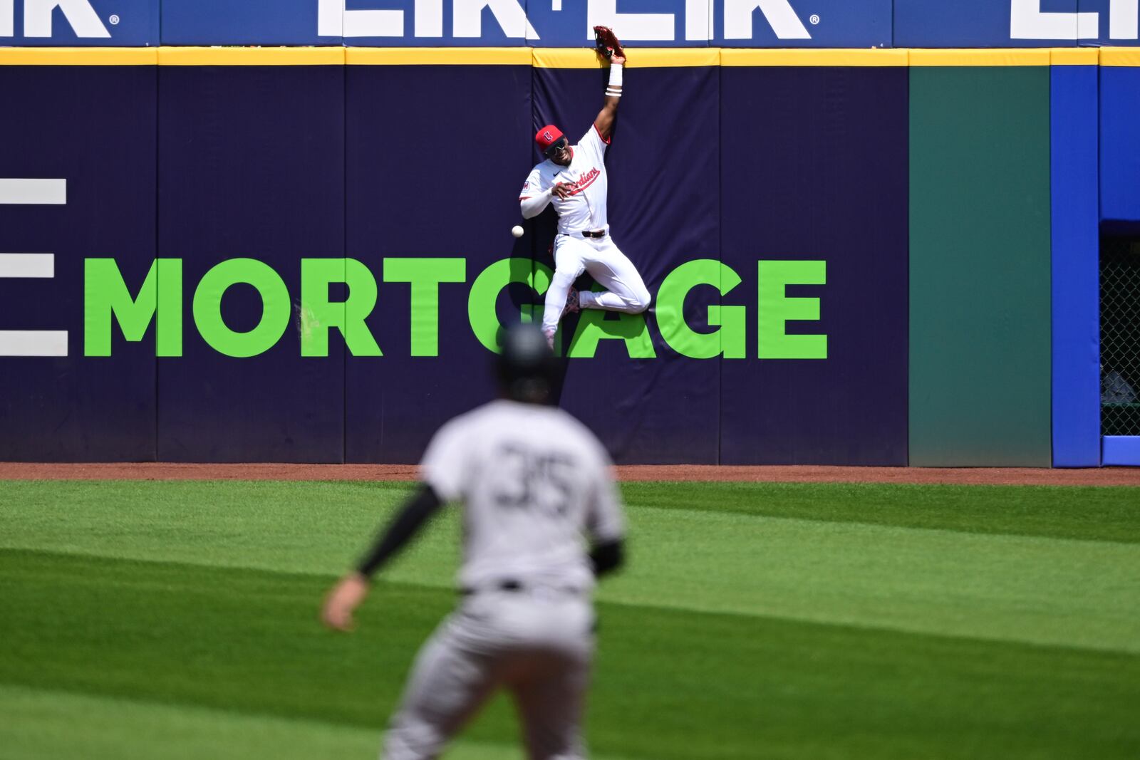 Cleveland Guardians center fielder Angel Martinez jumps on the wall but can't get to the ball hit by New York Yankees' Paul Goldschmidt during the first inning of a baseball game Wednesday, April 23, 2025, in Cleveland. Goldschmidt hit an RBI double. (AP Photo/David Dermer)