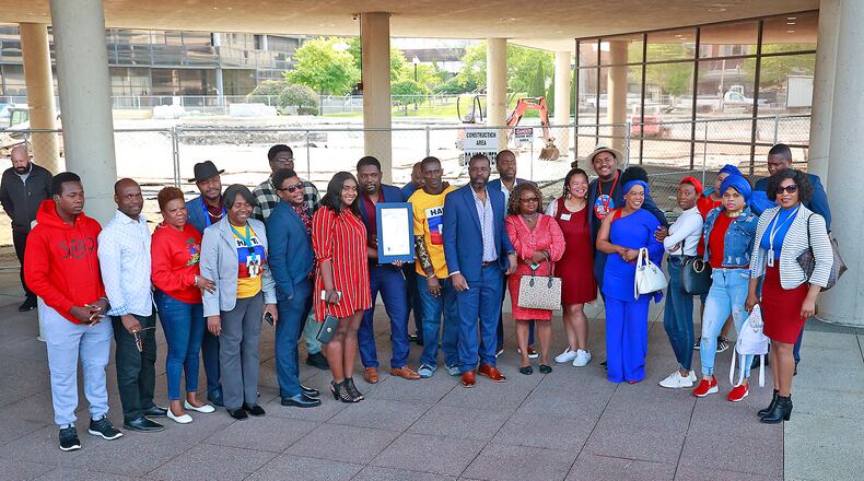 A group of Haitians pose for a picture during a ceremony Thursday, May 18, 2023 to raise the Haitian flag for the Flag Day holiday in Haiti. BILL LACKEY/STAFF