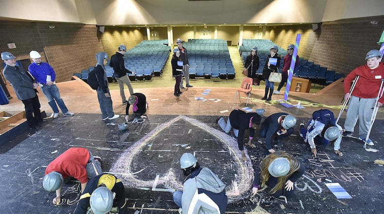 Springfield High School students use chalk to draw hearts on the stage in the auditorium at the former South High School. Springfield City School District alumni John Legend has announced plans to raise funds to renovate the auditorium. Bill Lackey/Staff