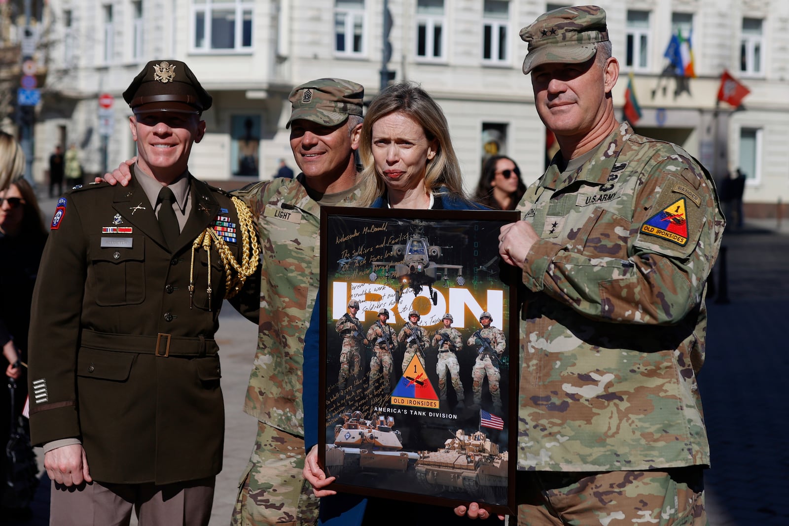 U.S. Ambassador to Lithuania Kara C. McDonald, center, poses for a photo with U.S. Army officers holding a poster after a solemn farewell ceremony at Cathedral Square in Vilnius, Lithuania, Thursday, April 3, 2025 for the US soldiers who died during training exercise. (AP Photo/Mindaugas Kulbis)