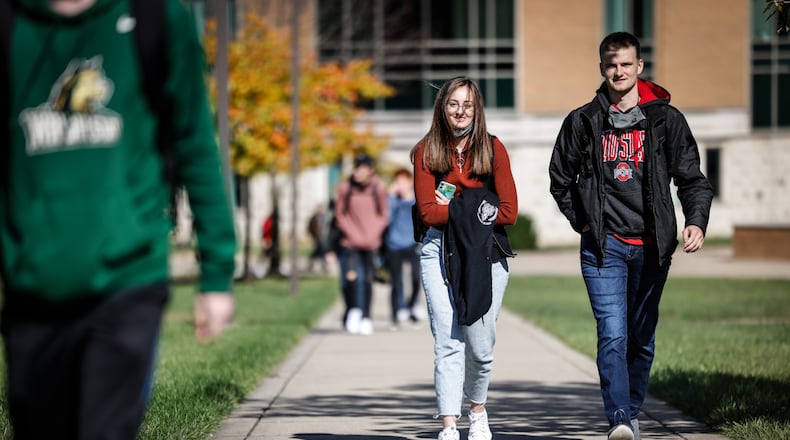 Wright State University students hustle to class Tuesday Oct. 26, 2021. Wright State's enrollment was down slightly this year, However, the university says about 400 more students enrolled this fall than was expected. Wright State has seen enrollment fall for the last several years. JIM NOELKER/STAFF