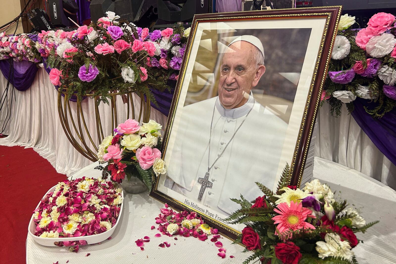 A portrait of Pope Francis is displayed for the people to offer their respects, following the announcement of his death, during a multi-faith assembly at the Sacred Heart Cathedral in New Delhi, India, Monday, April 21, 2025. (AP Photo/Piyush Nagpal)