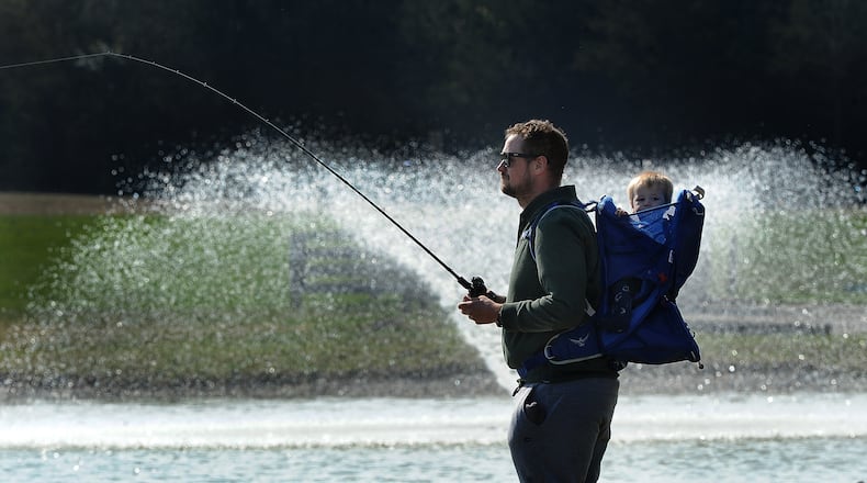 Jeremy Valentine along with his 10 month old son, Fisher, enjoy fishing Friday, March 29, 2024 at Miami View Park on Munger Road. MARSHALL GORBY\STAFF