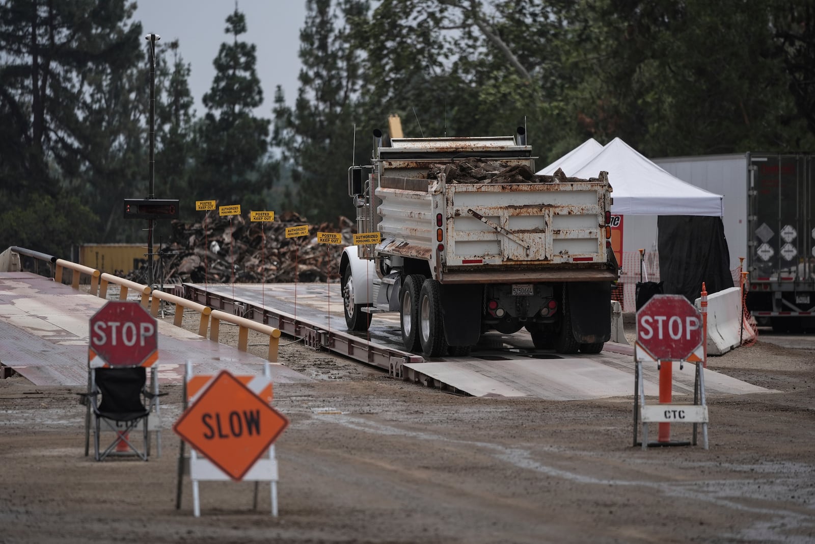 A dump truck carrying debris removed from January wildfires arrives at a recycling facility set up on a golf course in Altadena, Calif., Wednesday, June 4, 2025. (AP Photo/Jae C. Hong)