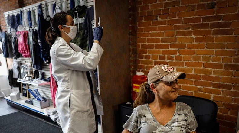 Marcie Perry rolls-up her sleeve for a flu shot by Germantown Pharmacy pharmacist, Katie Parry Monday Sept. 20, 2021. JIM NOELKER/STAFF
