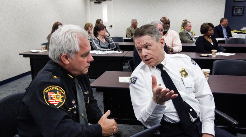 Montgomery County Sheriff Phil Plummer and Dayton police Chief Richard Biehl talk during a steering committee meeting of the Community Overdose Action Team in November 2016. CHRIS STEWART / STAFF