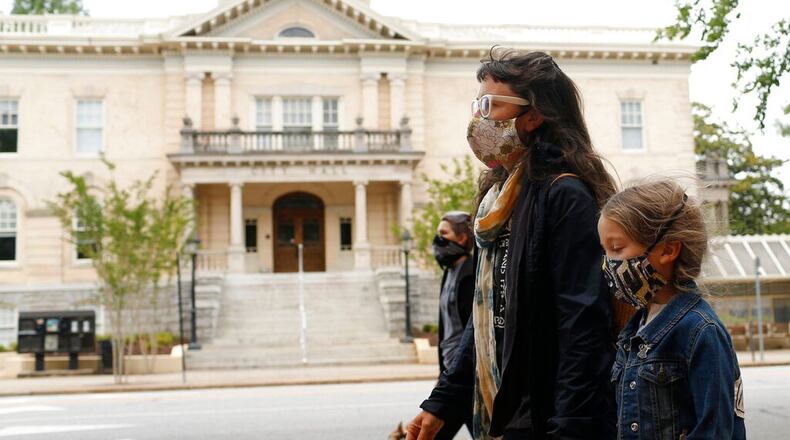 Athenians walk past City Hall in Athens, Ga, to honor the life of Ahmaud Arbery on Friday, May 8, 2020. Arbery was shot and killed while jogging in Glynn County, Ga., in February months later on May 5, graphic footage of the shooting was made public and two men Gregory McMichael, 64, and his son Travis McMichael, 34, were each charged with murder and aggravated assault and arrested. (Joshua L. Jones/Athens Banner-Herald via AP) (Joshua L. Jones/AP)