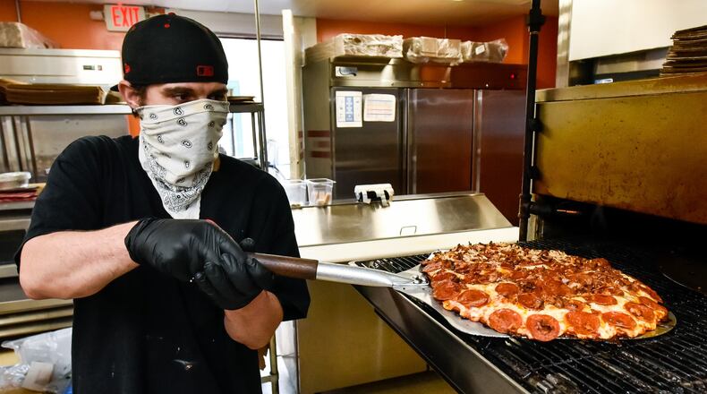 Jonathon Turner makes a pizza at Don’s Pizza on Central Avenue Wednesday, April 29 in Middletown. Don’s Pizza is open for carryout and delivery while the dining room is closed due to coronavirus pandemic. NICK GRAHAM/STAFF