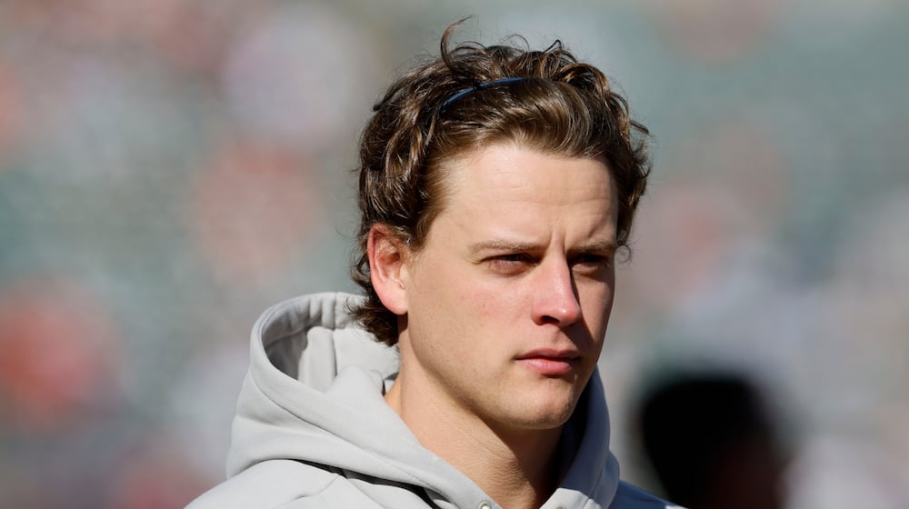 Injured Cincinnati Bengals quarterback Joe Burrow walks on the field before an NFL football game against the New England Patriots, Sunday, Nov. 23, 2025, in Cincinnati. (AP Photo/Jay LaPrete)
