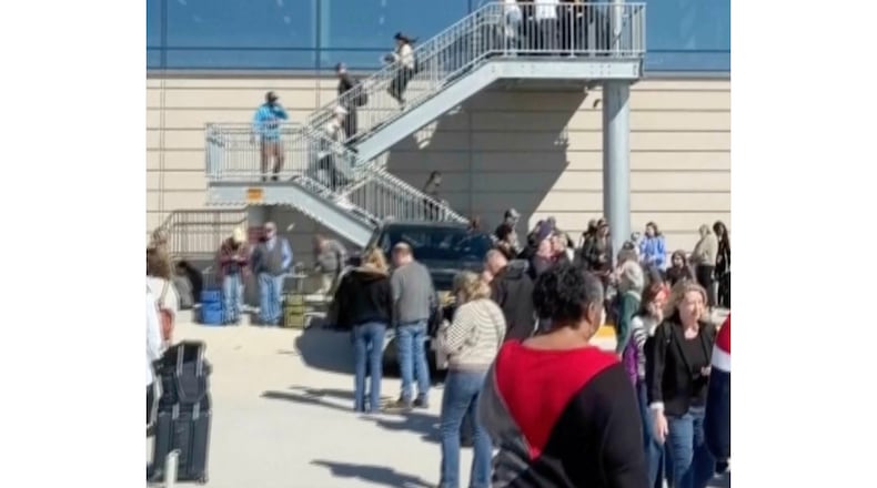 This image taken from video provided by Logan Hawley shows people standing on a tarmac outside of terminals at the Kansas City International Airport in Kansas City, Mo., Sunday, March 8, 2026 (Logan Hawley via AP)