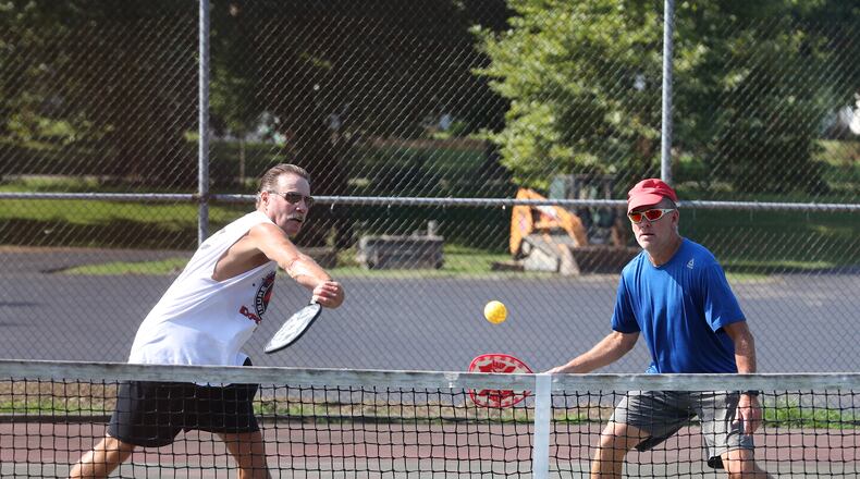 Dave Gordin, left, and Ten Ober play pickle ball at Snyder Park in August. The tennis/pickle ball courts are scheduled to by resurfaced later this year. BILL LACKEY/STAFF