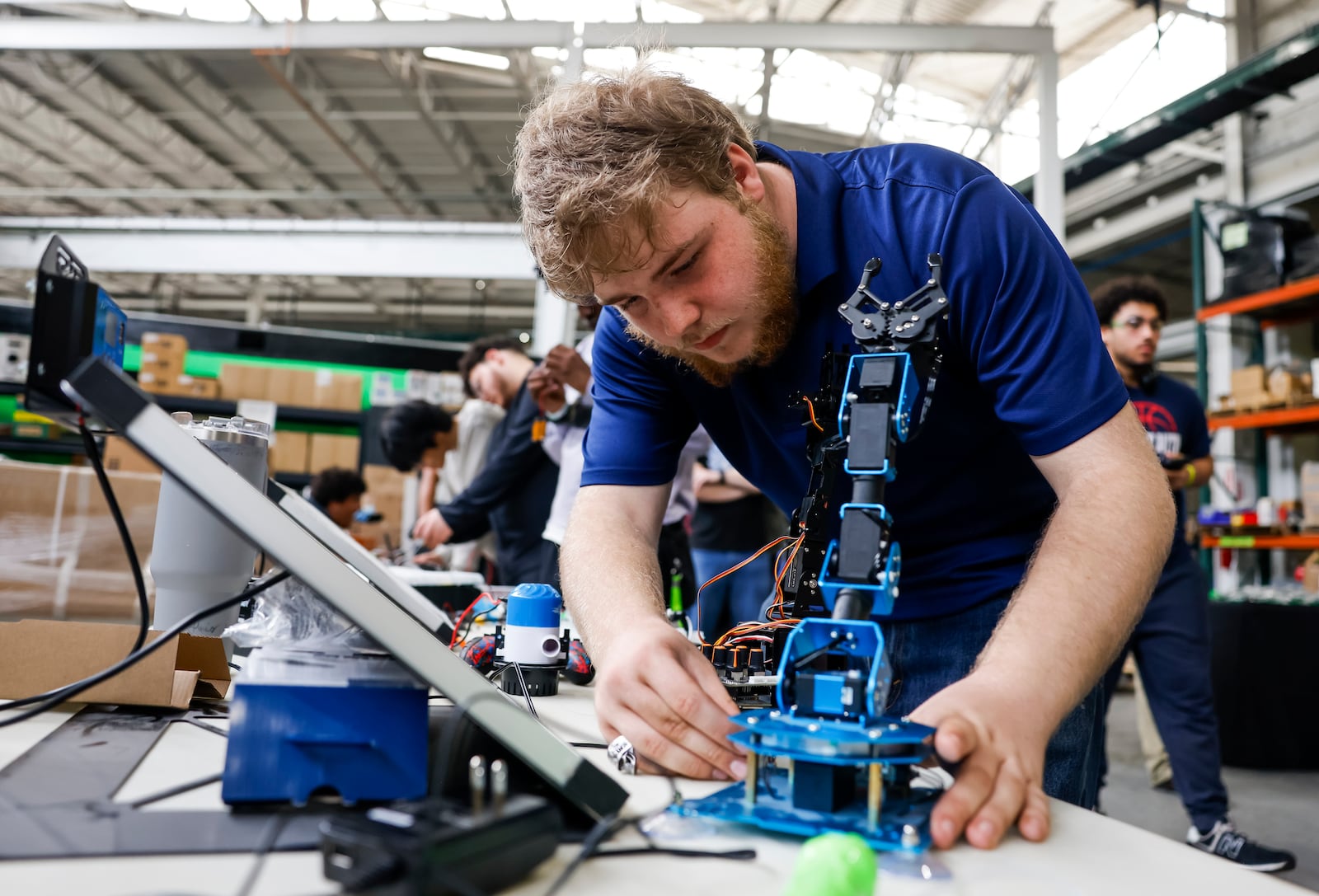Hamilton High School student Daniel Lefevers looks at a robot during a tour at Darana Hybrid Friday, April 25, 2025 in Hamilton. Darana Hybrid has partnered with Hamilton High School for a construction and manufacturing pre-apprenticeship program for students to learn about diverse career and educational pathways. NICK GRAHAM/STAFF