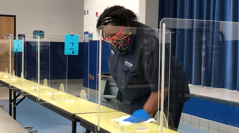 Dayton Public Schools staff work to keep cafeteria tables clean and sanitized at River's Edge Montessori School in November 2020. CONTRIBUTED PHOTO