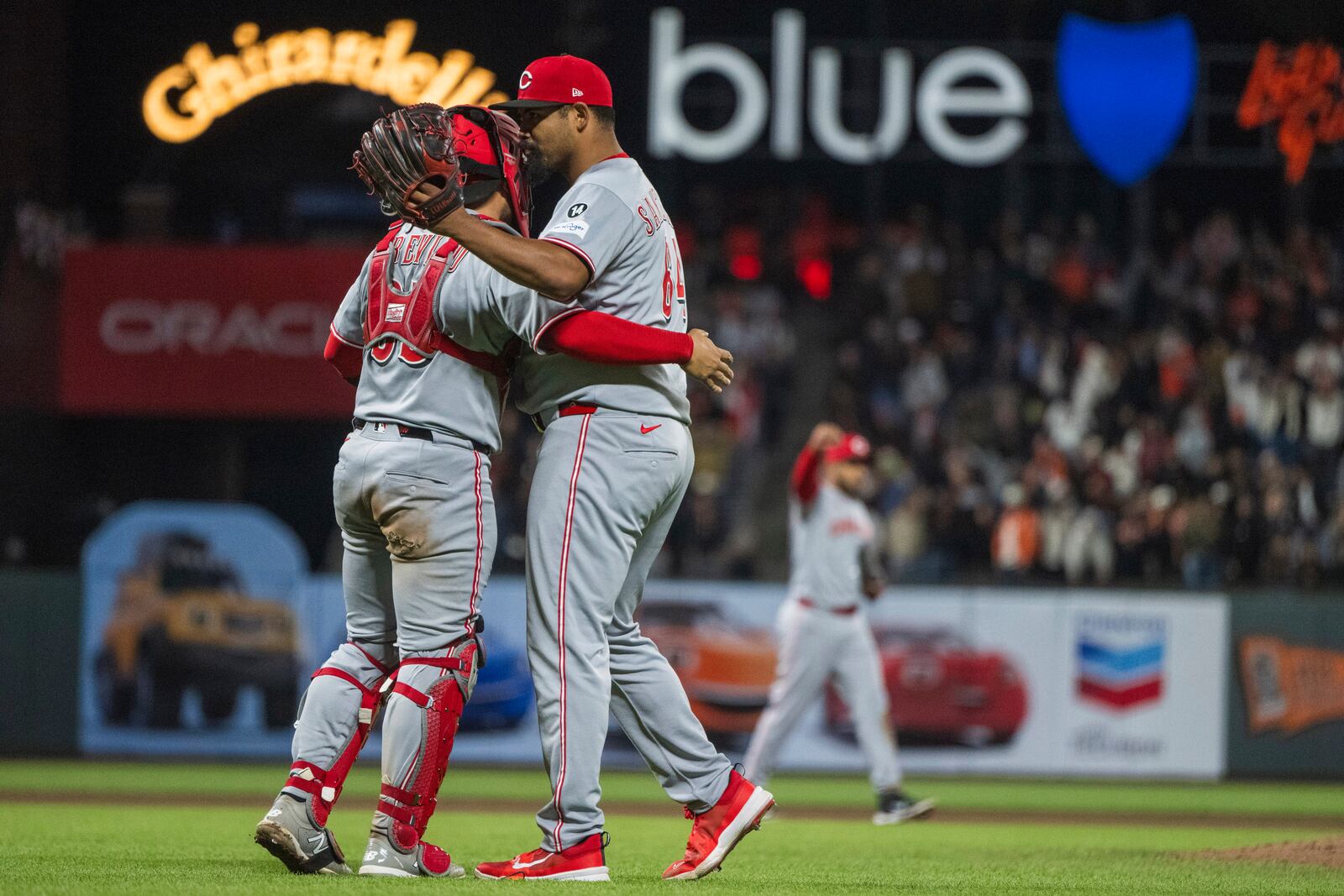 Cincinnati Reds pitcher Tony Santillan (64) celebrates his save with Jose Trevino (35) after a baseball game against the San Francisco Giants in San Francisco, Monday, April 7, 2025. (AP Photo/Nic Coury)