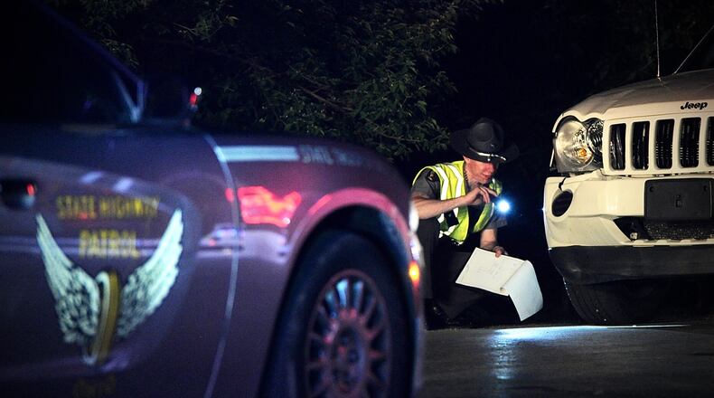 A State Highway patrol trooper surveys the damage to a white Jeep on Crabill Road that struck two juveniles and a dog Tuesday in Clark County. The two juveniles were transported to the hospital by medical helicopter and the dog was dead on the scene. MARSHALL GORBY \STAFF