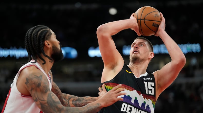 Denver Nuggets center Nikola Jokic (15), right, handles the ball as Chicago Bulls center Nick Richards (13) defends during the second half of an NBA basketball game Saturday, Feb. 7, 2026, in Chicago. (AP Photo/Erin Hooley)