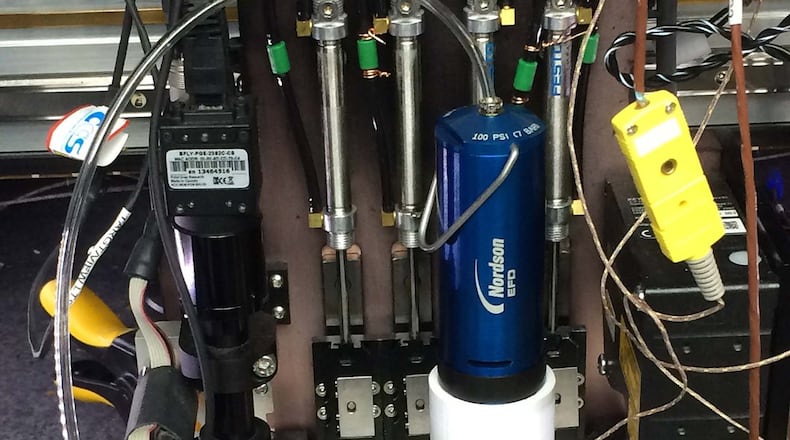 Direct ink printing is performed with a 3D printer using epoxy with chopped fiber. The pressure pump provides pressure to force the resin through the nozzle. (U.S. Air Force photo/Donna Lindner)