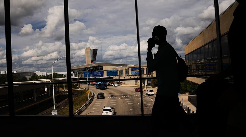 Passengers walk from a terminal at Philadelphia International Airport in Philadelphia, Tuesday, Oct. 7, 2025. (AP Photo/Matt Rourke)