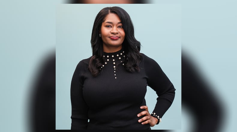 Stacey Harden poses at Daybreak Dayton on Wednesday, Dec. 17. Harden, who is now a massage therapist, credits her time with the organization for helping her. BRYANT BILLING/STAFF