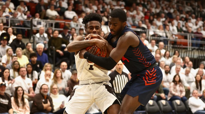 Dayton's Kobe Elvis and St. Bonaventure's Kyrell Luc compete for a ball on Saturday, Feb. 4, 2023, at the Reilly Center in St. Bonaventure, N.Y. David Jablonski/Staff