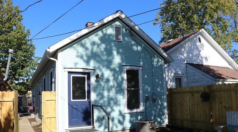 The property includes a private back yard surrounded by a wooden privacy fence and has two off-alley parking spaces.