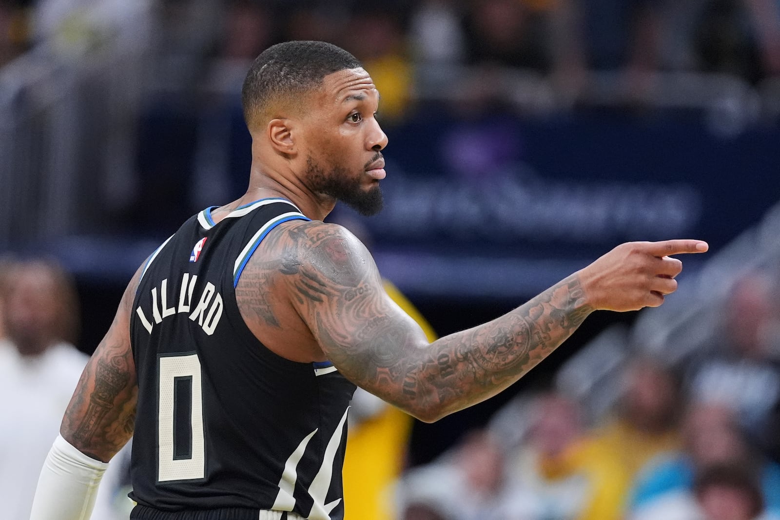 Milwaukee Bucks guard Damian Lillard (0) gestures after a three-point basket against the Indiana Pacers during the second half of a first-round NBA basketball playoff game in Indianapolis, Tuesday, April 22, 2025. (AP Photo/Michael Conroy)