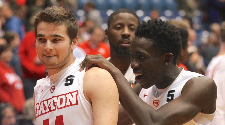 Dayton’s Joey Gruden and Jeremiah Bonsu leave the court after a victory against Saint Joseph’s College on Tuesday, Dec. 6, 2016, at UD Arena. David Jablonski/Staff
