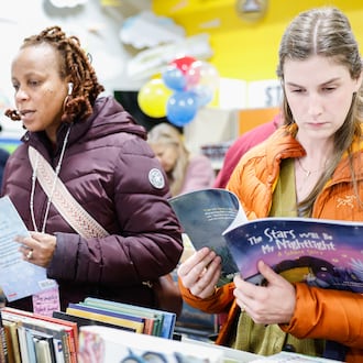 Mara Fogg (right) looks at a book while Taundra Green browses during Crayons to Classrooms fourth annual Book Give Back Event on Tuesday, Dec. 2 in Dayton. Fogg teaches at Fairview Elementary School in Dayton and Green teaches at Westwood Elementary in Dayton. The charity gave away over 11,000 books at last year's event and had over 30,000 to give away this year. BRYANT BILLING/STAFF